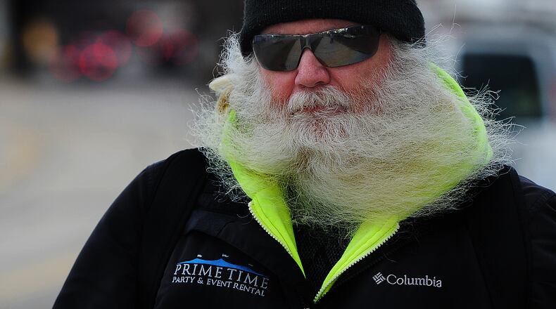 The beard of John K. Berger gets blowed around as he walks near downtown Dayton on a windy Thursday afternoon Feb. 9, 2023. MARSHALL GORBY\STAFF
