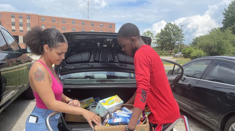 The Community Marketplace mobile food pantry student volunteer Emmitt Higgins, right, helps a student, Teesh J., at a recent food distribution event at Central State University's campus. ,The pantry happens the second Tuesday of every month to help students and nearby community members. ADRIENNE OGLESBY/STAFF