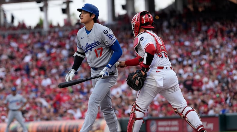 Los Angeles Dodgers' Shohei Ohtani, left, turns to walk to the dugout as Cincinnati Reds catcher Jose Trevino tags Othani out after dropping the third strike during the first inning of a baseball game, Tuesday, July 29, 2025, in Cincinnati. (AP Photo/Carolyn Kaster)