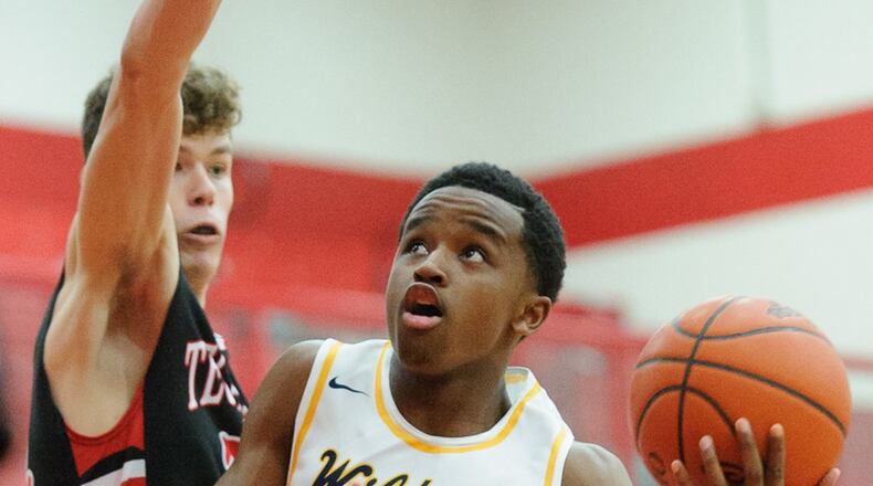 Springfield junior guard Michael Wallace shoots with pressure from Tecumseh’s Ross Warren during a sectional quarterfinal win for the Wildcats on Friday night at Trotwood. BRYANT BILLING / CONTRIBUTED