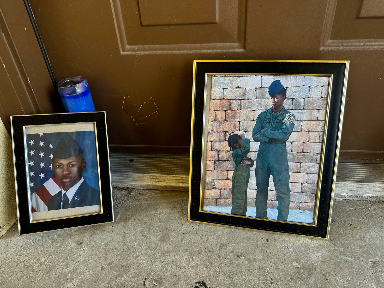 FILE - Candles and framed photos of Roger Fortson, a U.S. Air Force senior airman who was fatally shot by a Fla. sheriff's deputy on May 3, 2024, sit in the doorway of the apartment where he was killed in Fort Walton Beach, Fla., on Aug. 23. (AP Photo/Kate Payne, File)