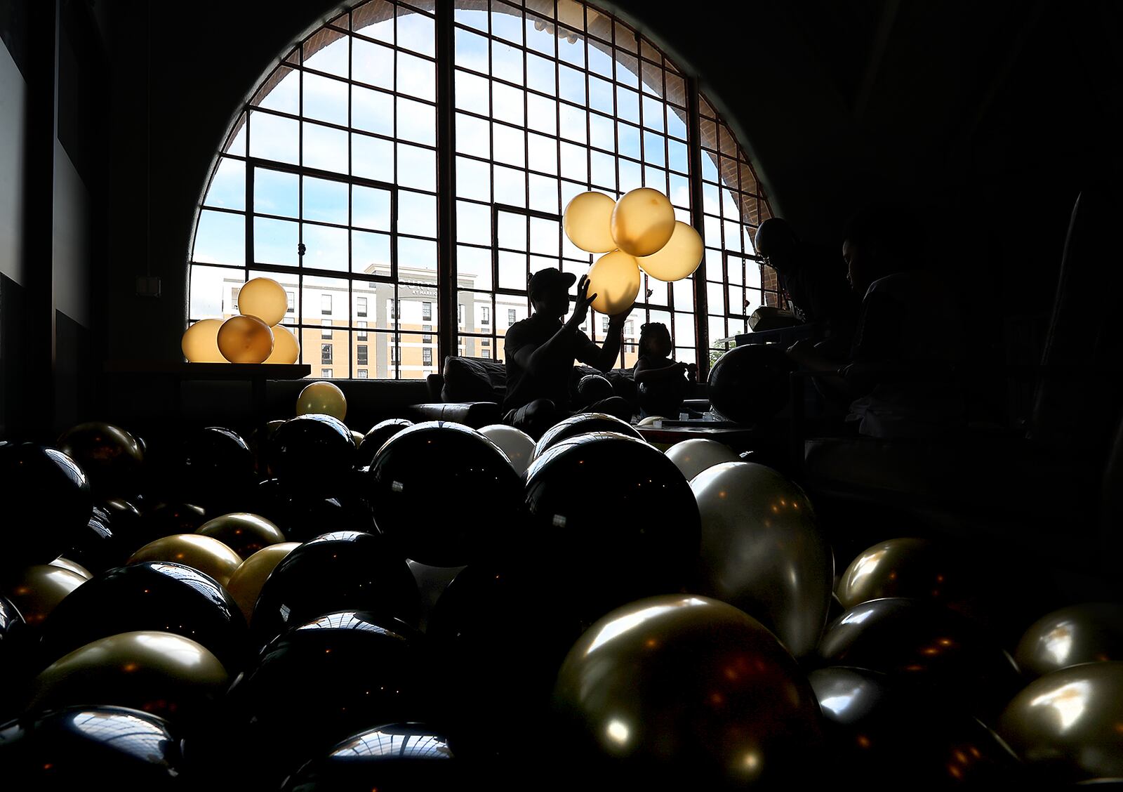 The second floor of the Springfield COhatch is filled with gold, silver and black balloons as the family of Jamon Miller inflates dozens of balloons for a party Monday celebrating Miller's graduation from Shawnee High School. BILL LACKEY/STAFF