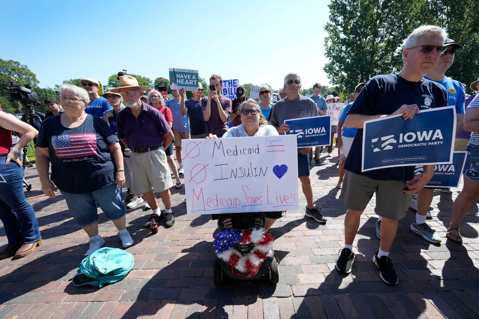 Local residents listen to a speech during an Iowa Democratic Party rally, Thursday, July 3, 2025, in Windsor Heights, Iowa. (AP Photo/Charlie Neibergall)
