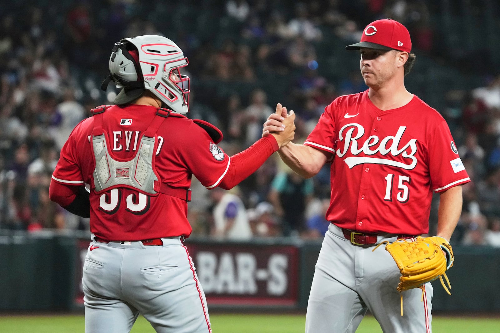 Cincinnati Reds catcher Jose Trevino (35) and pitcher Emilio Pagán celebrate after defeating the Arizona Diamondbacks during a baseball game Sunday, Aug 24, 2025, in Phoenix. (AP Photo/Rick Scuteri)