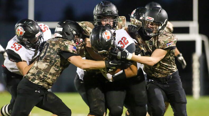 Cutline2: A gang of Graham High School defenders bring down Tecumseh junior Josiah Botello during their game on Friday night at Dallas Stadium in St. Paris. The Falcons won 22-0. CONTRIBUTED PHOTO BY MICHAEL COOPER