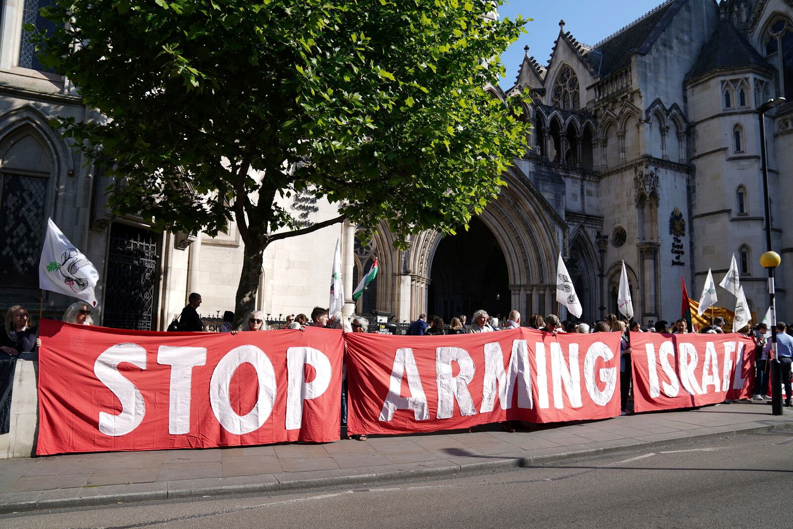 Demonstrators gather outside the Royal Courts of Justice in London, where Palestinian human rights organization Al-Haq is taking legal action against the Department for Business and Trade over several decisions, Tuesday May 13, 2025. (Ben Whitley/PA via AP)