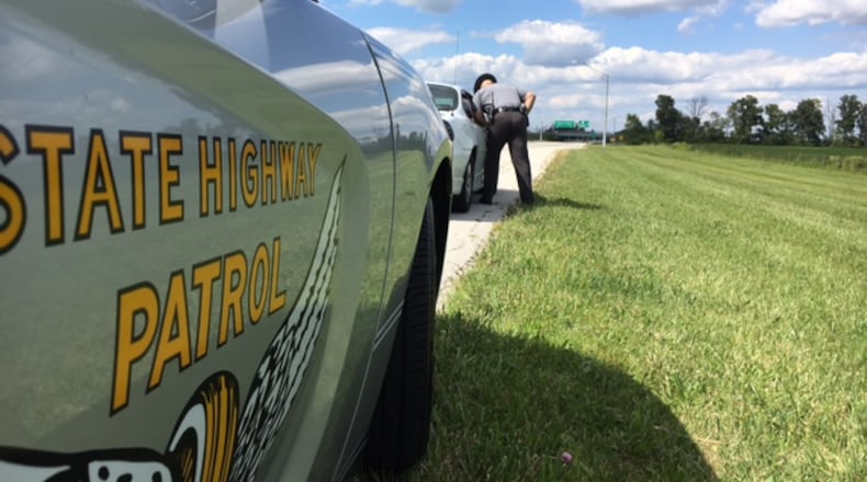 Ohio Highway Patrol Sgt. Frank Simmons speaks with a driver he pulled over on the access road to Dayton International Airport. Drivers near airports and on Friday afternoons are often distracted, law enforcement officers say. THOMAS GNAU/STAFF