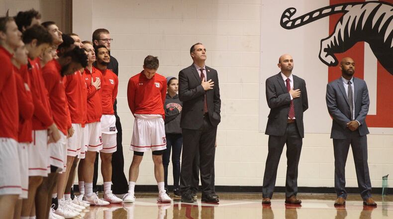 Wittenberg coach Matt Croci, center, stands for the national anthem before a game against Wabash on Wednesday, Feb. 13, 2019, at Pam Evans Smith Arena in Springfield. David Jablonski/Staff