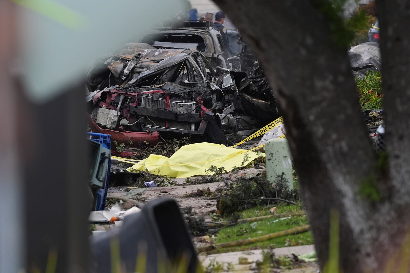 Authorities work the scene where a small plane crashed into a San Diego neighborhood, setting several homes on fire and forcing evacuations along several blocks early Thursday, May 22, 2025. (AP Photo/Gregory Bull)