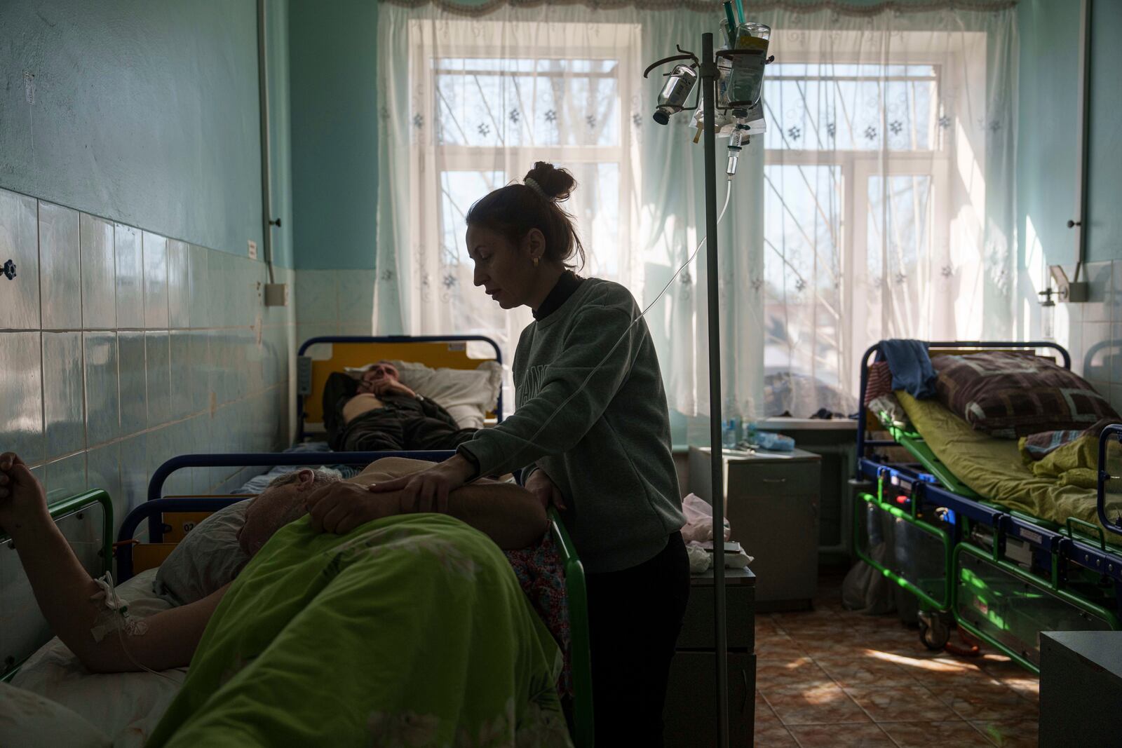 Hanna seeks to her husband Victor Voitenko, injured in a deadly Palm Sunday Russian attack on Sumy on April 13, at a hospital in Sumy, Ukraine, Tuesday, April 15, 2025. (AP Photo/Evgeniy Maloletka)