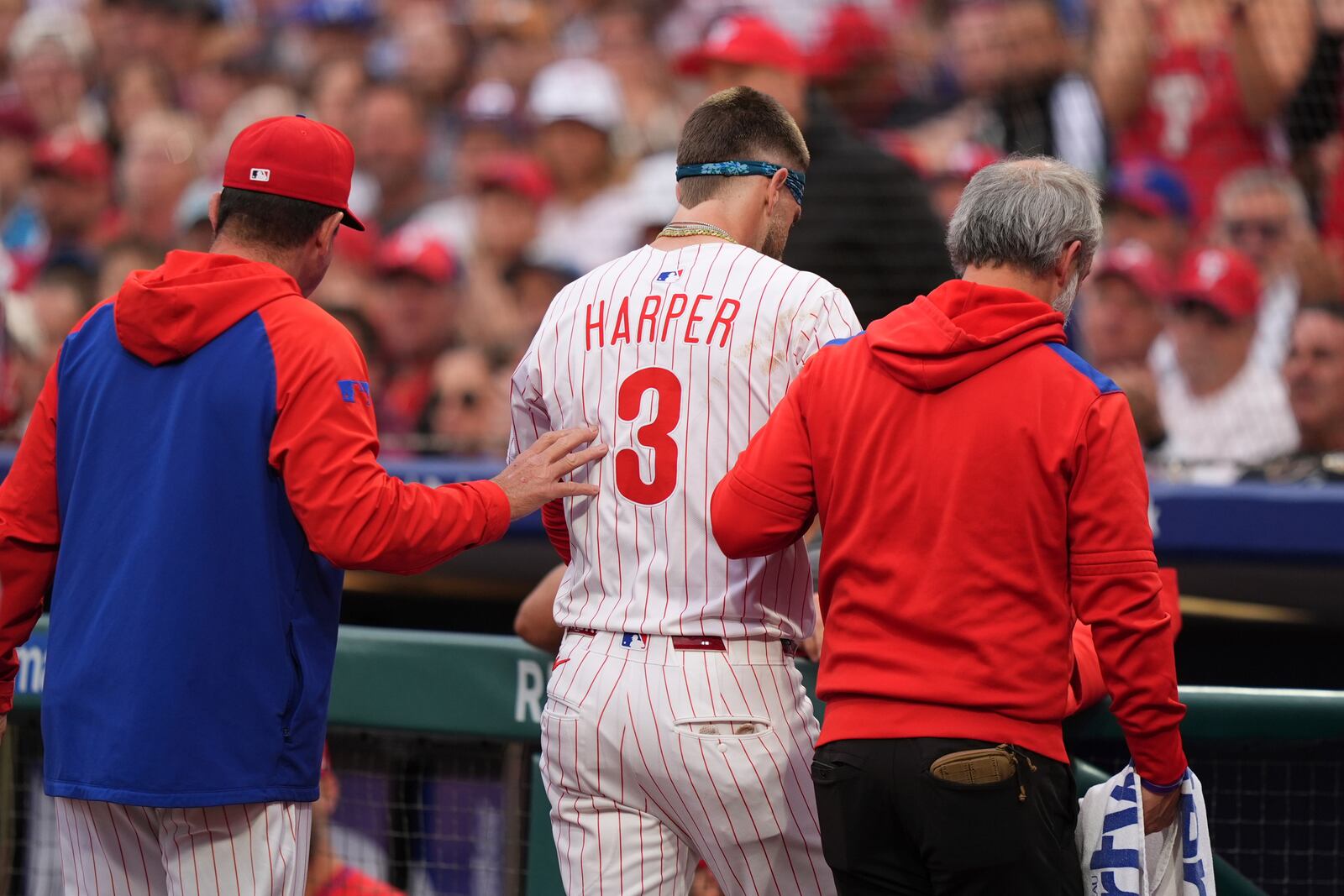 FILE - Philadelphia Phillies' Bryce Harper is led to the dugout after being hit by a pitch from Atlanta Braves' Spencer Strider plays during a baseball game, Tuesday, May 27, 2025, in Philadelphia. (AP Photo/Matt Slocum)