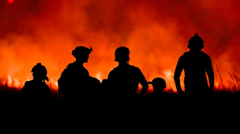 FILE — U.S. Special Operations Service members are illuminated by the glow of orange flames from a brush fire caused by the continued firing of shoulder-fired rocket launchers at a remote range in Fort Chaffee, Ark., on Oct. 23, 2023. Troops whose jobs can expose them repeatedly to blasts from their own weapons have among the highest suicide rates in the armed forces, according to a new report by the Defense Department. (Kenny Holston/The New York Times)