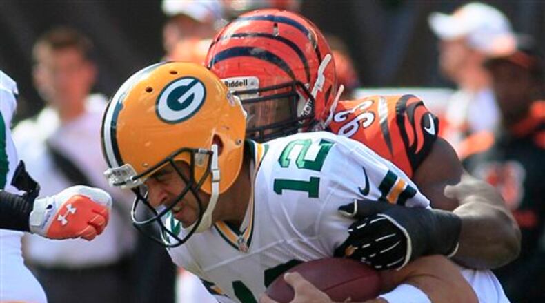 Green Bay Packers quarterback Aaron Rodgers (12) is sacked by Cincinnati Bengals defensive end Michael Johnson (93) in the first half of an NFL football game, Sunday, Sept. 22, 2013, in Cincinnati. (AP Photo/Tom Uhlman)