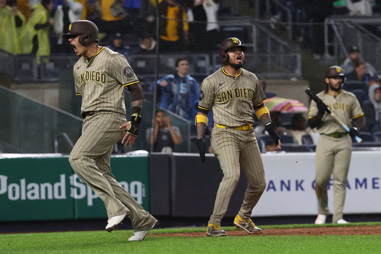 San Diego Padres' Manny Machado, left, and Luis Arraez, center, react after scoring on a single hit by Xander Bogaerts during the eighth inning of a baseball game against the New York Yankees, Monday, May 5, 2025, in New York. (AP Photo/Pamela Smith)