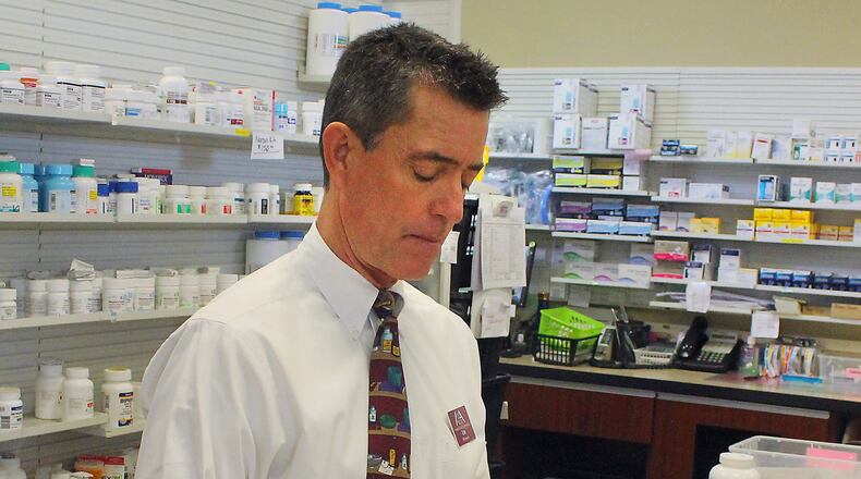 Pharmacist Eric Juergens of Madison Avenue Pharmacy counts opioid pills as he fills a prescription in Springfield on Tuesday morning. JEFF GUERINI/STAFF