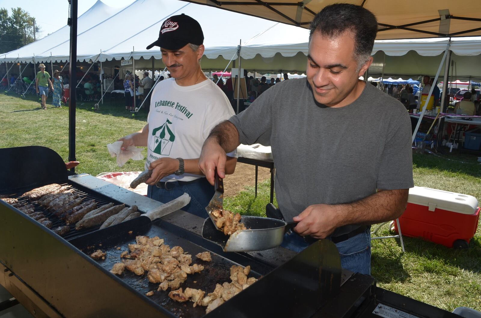 Will Thomas grilling kafta and Danny Slilaty grilling chicken for Shawarma sandwiches at the Dayton Lebanese Festival. (Submitted by the Dayton Lebanese Festival)