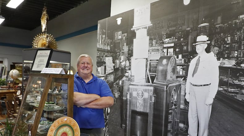 A large black and white photograph of the previous owner and the hardware store that used to be located at 15 Monument Square hangs behind Michael Manoloff, the new owner, in his business called Oxner’s General Store. Bill Lackey/Staff