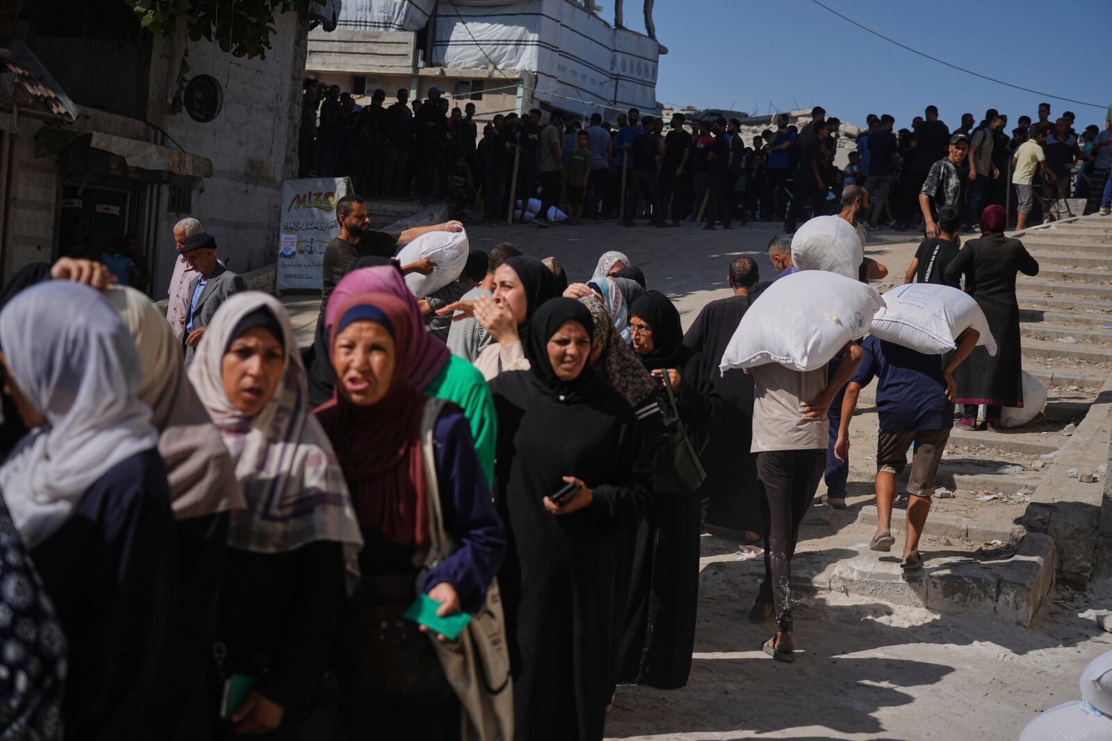 Palestinians line up to receive bags of flour distributed by the World Food Programme (WFP) in Gaza City, northern Gaza Strip, on Thursday, June 26, 2025. (AP Photo/Jehad Alshrafi)