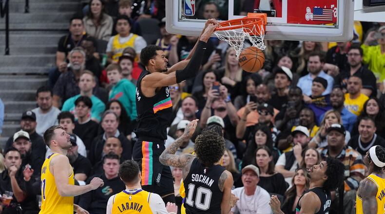 San Antonio Spurs forward Victor Wembanyama (1) scores against the Los Angeles Lakers during the second half of an NBA basketball game in San Antonio, Wednesday, Jan. 7, 2026. (AP Photo/Eric Gay)