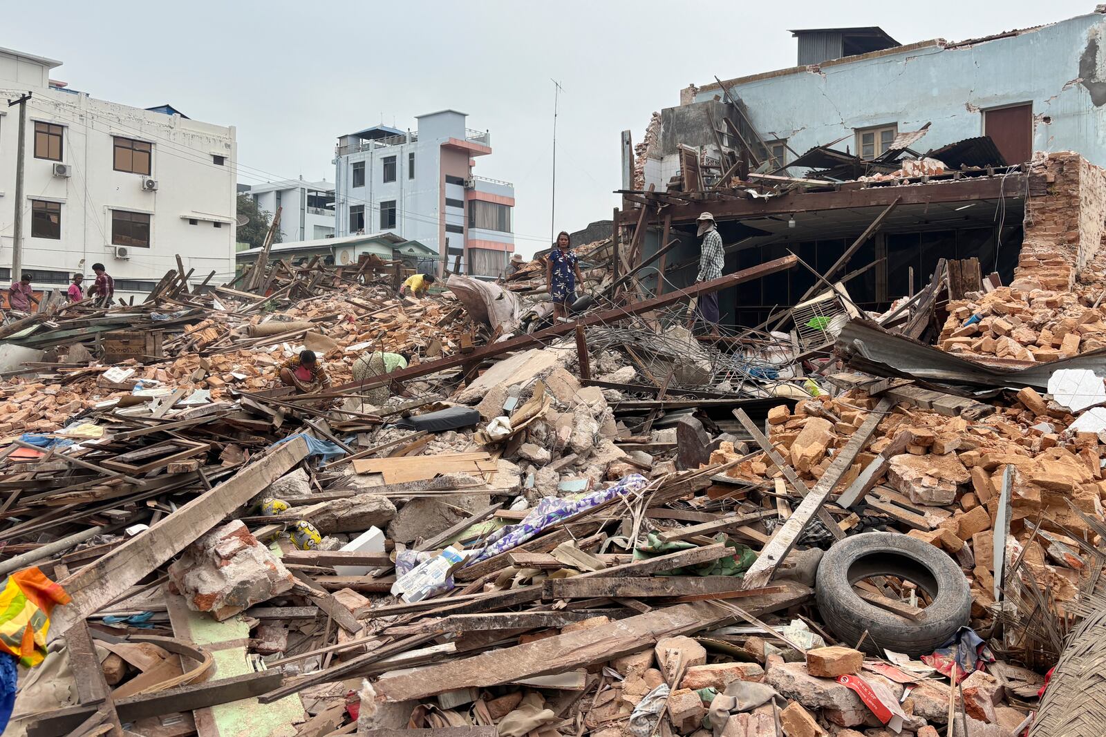 People clean debris from damaged buildings in the aftermath of an earthquake on March 28, in Naypyitaw, Myanmar, Monday, April 7, 2025. (AP Photo)