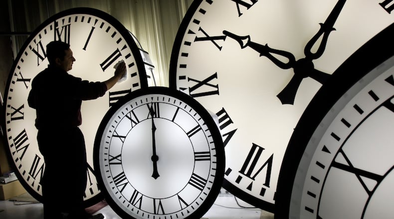 FILE - Electric Time Co. employee Walter Rodriguez cleans the face of an 84-inch Wegman clock at the plant in Medfield, Mass. Thursday, Oct. 30, 2008. (AP Photo/Elise Amendola, File)