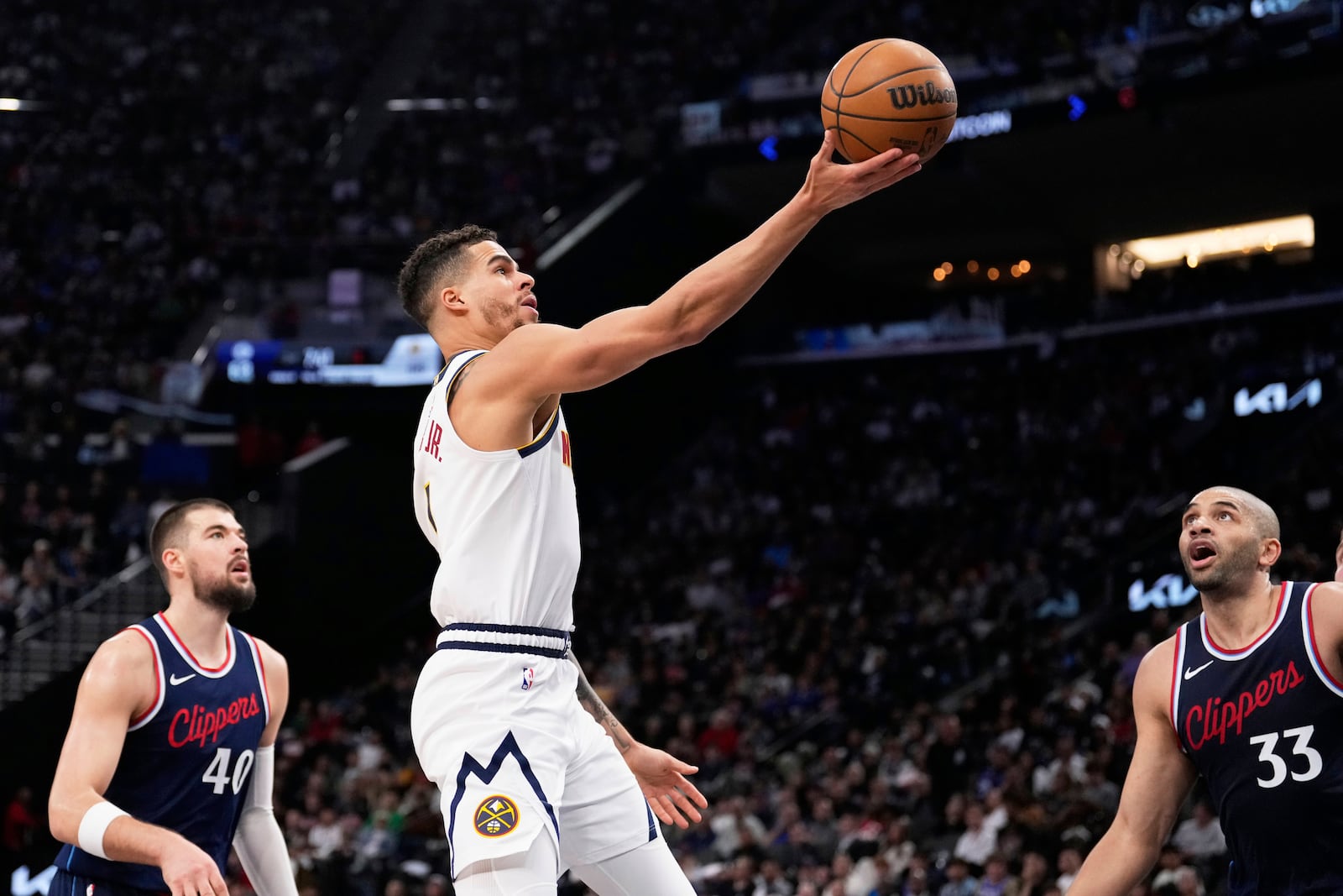 Denver Nuggets forward Michael Porter Jr., center, shoots as Los Angeles Clippers center Ivica Zubac, left, and forward Nicolas Batum defend during the second half in Game 6 of an NBA basketball first-round playoff series Thursday, May 1, 2025, in Inglewood, Calif. (AP Photo/Mark J. Terrill)