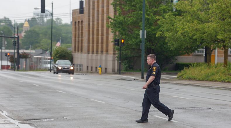A Springfield police officer crosses East North Street on Monday, May 12, 2025. JOSEPH COOKE/STAFF