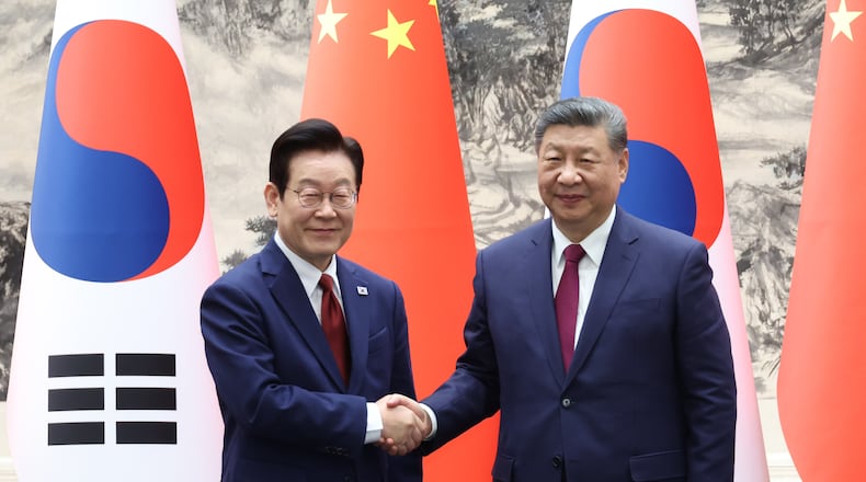 Chinese President Xi Jinping, right, shakes hands with South Korean President Lee Jae Myung, left, during a ceremony of the Memorandum of Understanding, (MOU) between South Korea and China in Beijing, China, Monday, Jan. 5, 2026. (Han Sang-kyun/Yonhap via AP)
