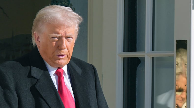 President Donald Trump and White House Chief of Staff Susie Wiles, reflected on door, leave to board Marine One, Tuesday, Jan. 13, 2026, in Washington. (AP Photo/Mark Schiefelbein)