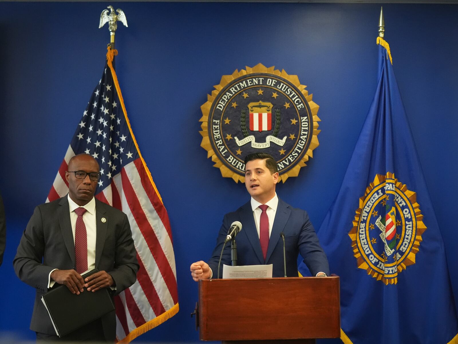 U.S. Attorney Bill Essayli, at podium with Akil Davis is the Assistant Director in Charge of the FBI's Los Angeles Field Office, left, answer questions during a news conference in Los Angeles, Wednesday, June 4, 2025. (AP Photo/Damian Dovarganes)