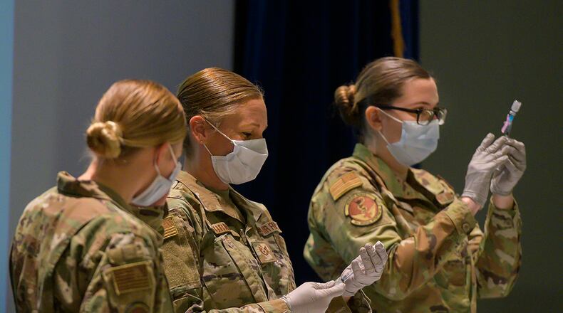 Staff Sgt. Allison Turner and Staff Sgt. Elizabeth Ciero, both with the 88th Healthcare Operations Squadron, fill syringes with the COVID-19 vaccine Jan. 8 in the Wright-Patterson Medical Center auditorium. The Airmen were preparing the syringes to vaccinate health care workers and other Phase 1 Airmen. U.S. AIR FORCE PHOTO/R.J. ORIEZ