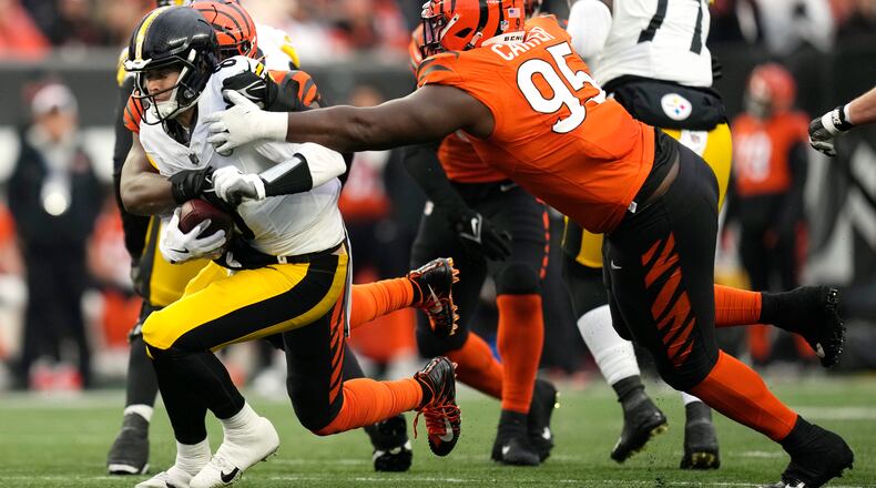 Pittsburgh Steelers quarterback Kenny Pickett (8) is sacked by Cincinnati Bengals defensive tackle Zach Carter, right, and Myles Murphy, rear, during the second half of an NFL football game in Cincinnati, Sunday, Nov. 26, 2023. (AP Photo/Carolyn Kaster)
