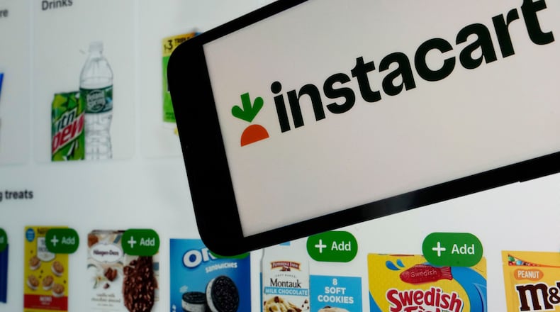 FILE - An instacart logo and an instacart webpage are shown in this photo, in New York, on Sept. 6, 2023. (AP Photo/Richard Drew, File)