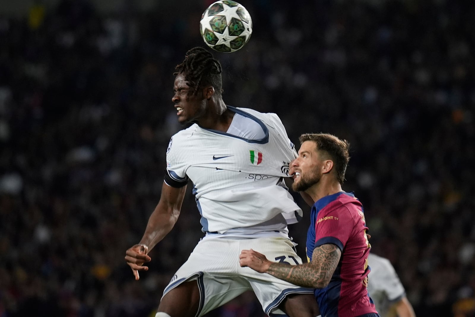 Inter Milan's Yann Bisseck, left, and Barcelona's Ronald Araujo fight for the ball during the Champions League semifinal first leg soccer match between Barcelona and Inter Milan in Barcelona, Spain, Wednesday, April 30, 2025. AP Photo/Emilio Morenatti)