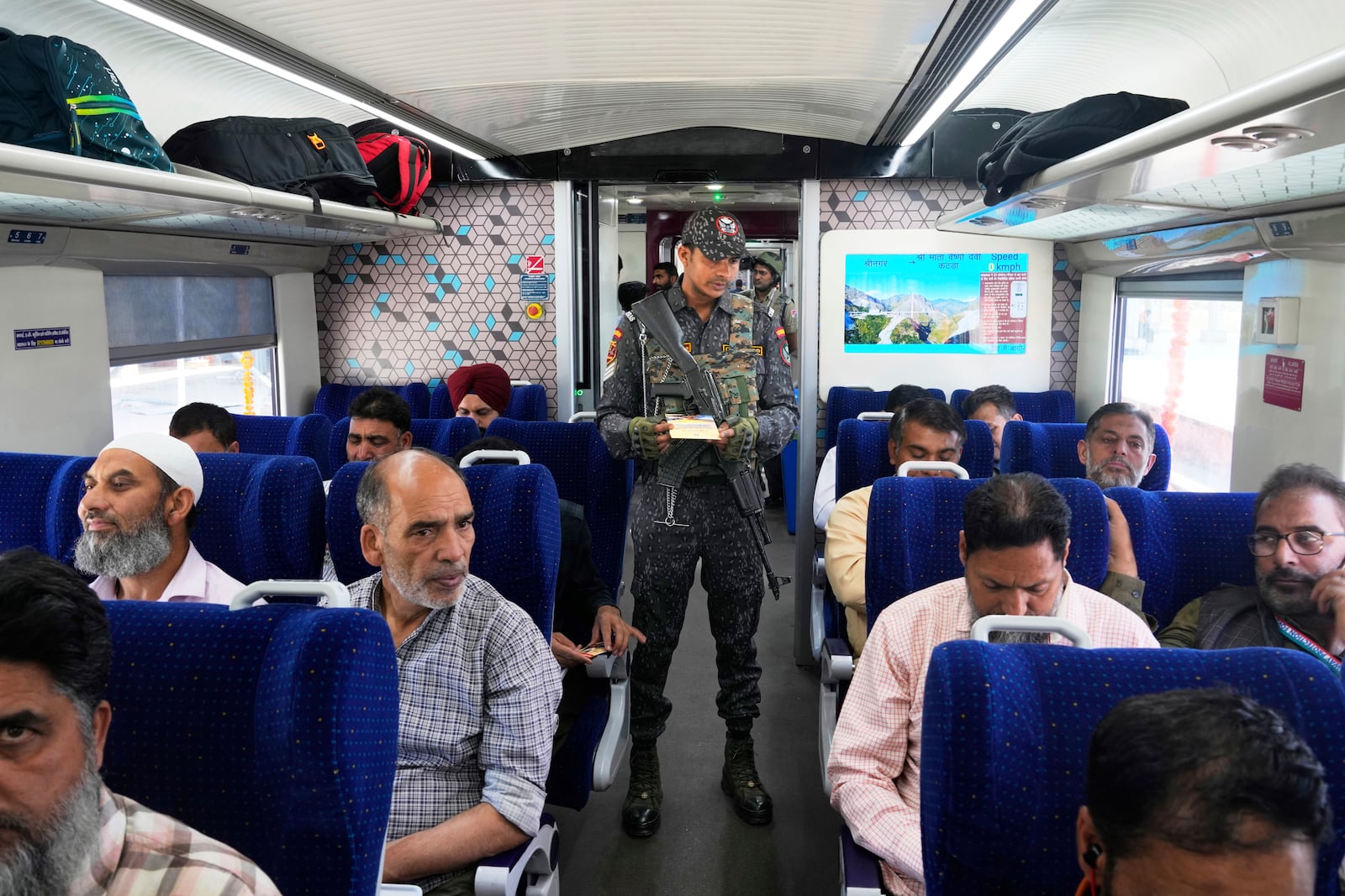 An armed commando inspects tickets inside Vande Bharat Express train soon to be inaugurated to run between Srinagar and Katra, in Srinagar, Indian controlled Kashmir, Friday, June 6, 2025. (AP Photo/Dar Yasin)