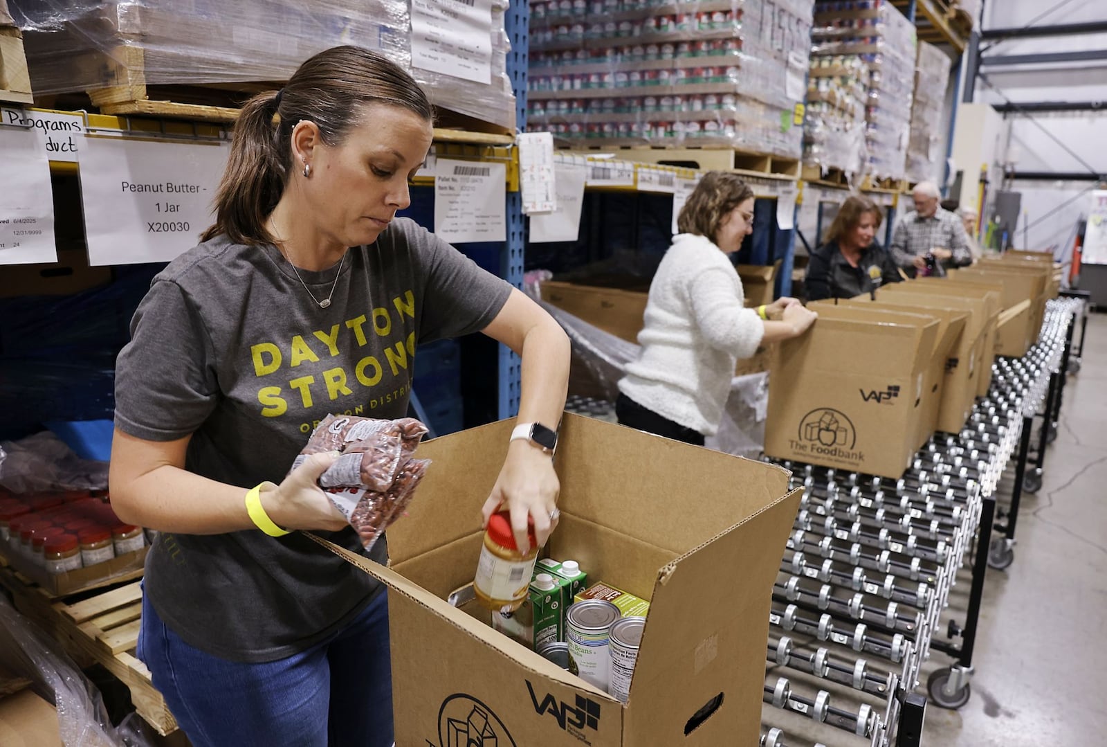 Volunteer Brandi Walters packs boxes for delivery to those in need at The Foodbank, Inc. Monday, Oct. 27, 2025 in Dayton. NICK GRAHAM/STAFF