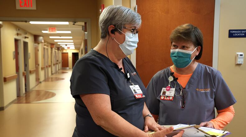 Nurses confer over a patient's chart Tuesday, Jan. 4, 2022 at the Ohio Valley Surgical Hospital. BILL LACKEY/STAFF