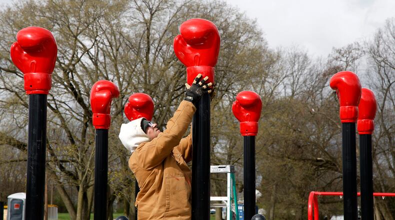 Lester Yoder, from Woodland Installations, adds giant, metal boxing gloves to the new boxing-themed playground being installed at Davey Moore Park Wednesday, April 3, 2024. The new playground, which honors boxing legend Davey Moore, is part of the nearly three-quarters of a million dollars that National Trail Parks and Recreation District is spending on improvements to the park on the southwest side of Springfield. BILL LACKEY/STAFF
