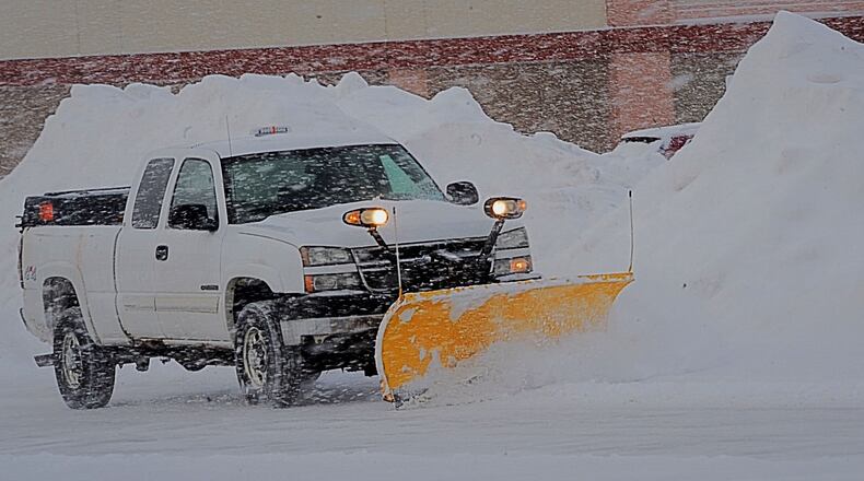 A snow plow works to clear the lot at the South Towne Center near the Dayton Mall Tuesday, February 16, 2021. MARSHALL GORBY\STAFF