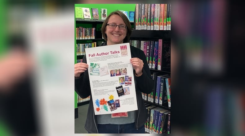 Catie Stewart, adult programming coordinator, holding a poster for the author series. Contributed