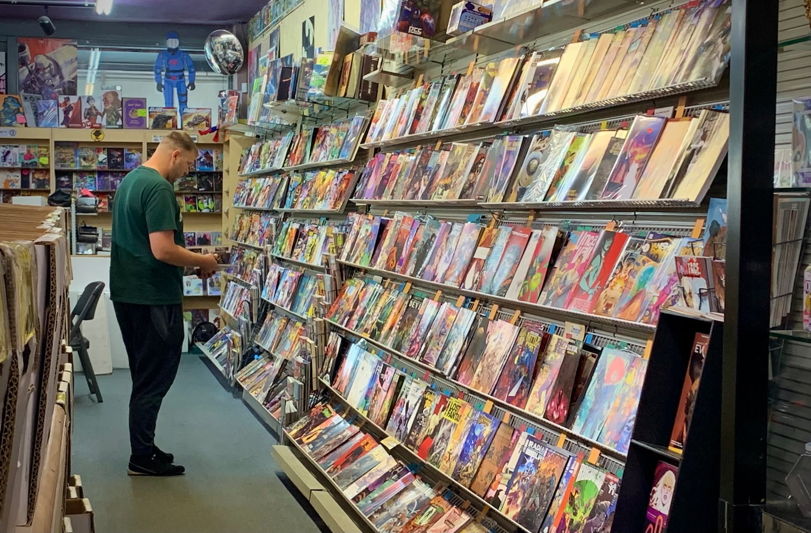 A patron peruses the stacks of comic books at Bell, Book and Comic in Dayton, Friday May 23, 2025. LONDON BISHOP/STAFF