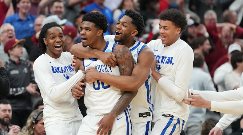 Kentucky's Otega Oweh (00) is congratulated by teammates after sinking a basket at the end of regulation to send the game into overtime in the first round of the NCAA college basketball tournament against Santa Clara, Friday, March 20, 2026, in St. Louis. (AP Photo/Jeff Roberson)