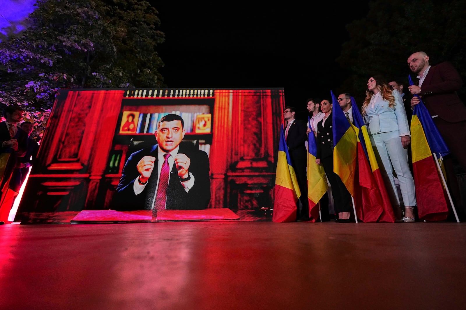 Presidential candidate George Simion addresses supporters via video link after polls closed for the first round of the country's presidential election redo in Bucharest, Romania, Sunday, May 4, 2025. (AP Photo/Andreea Alexandru)