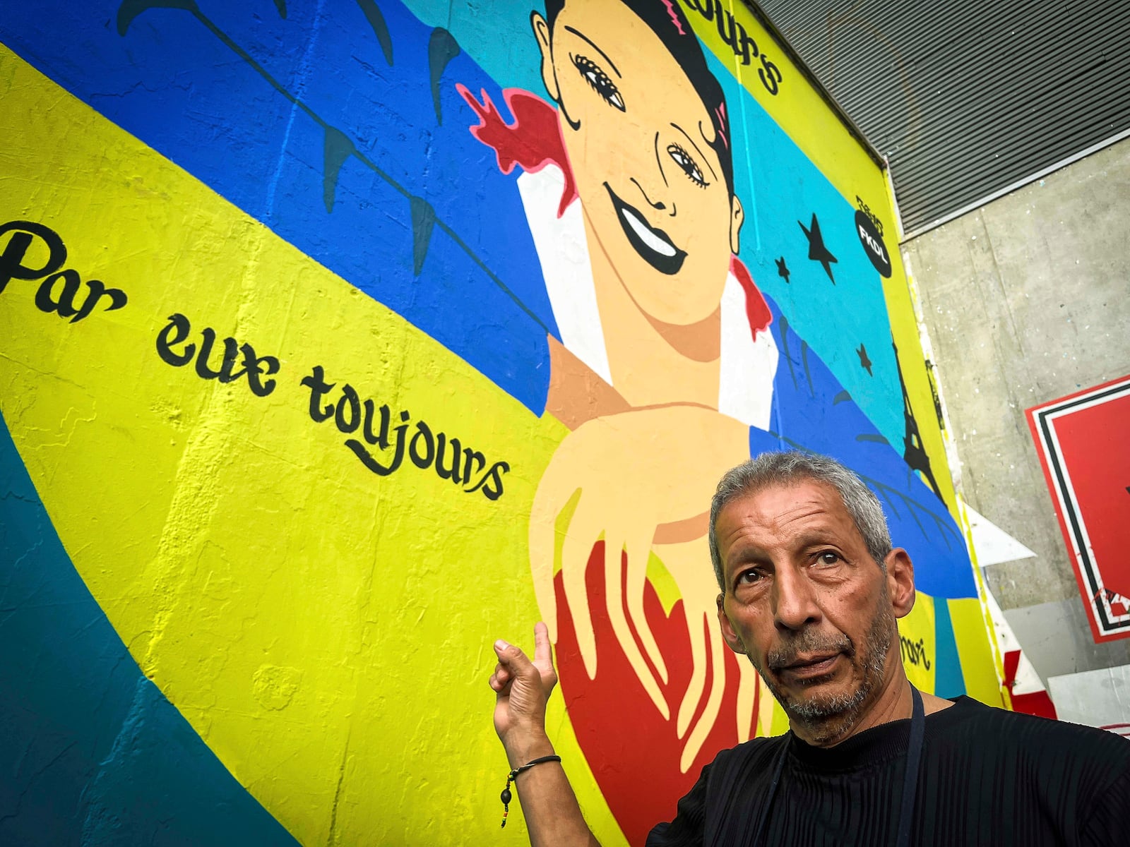 Brian Baker, son of U.S.-French entertainer and civil rights activist Josephine Baker, stands in front of a new mural of his mother painted by artist Franck Duval, aka FKDL, in Paris, Saturday, July 19, 2025. (AP Photo/Thomas Padilla)