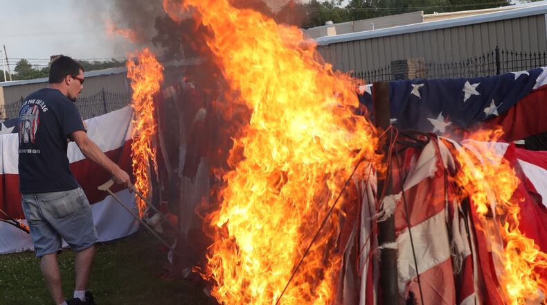 Members of American Legion Post 286 properly disposes of worn and tattered flags during a flag retirement ceremony in New Carlisle Friday evening.