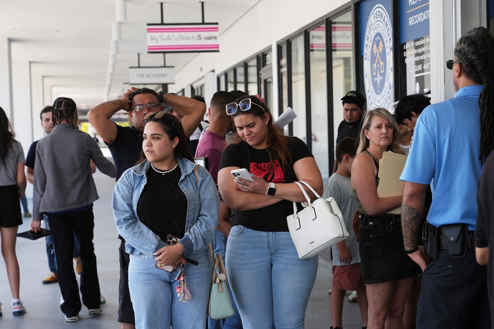 People stand in line outside of a Miami-Dade County Office of the Tax Collector Tuesday, May 6, 2025, in Miami. (AP Photo/Lynne Sladky)