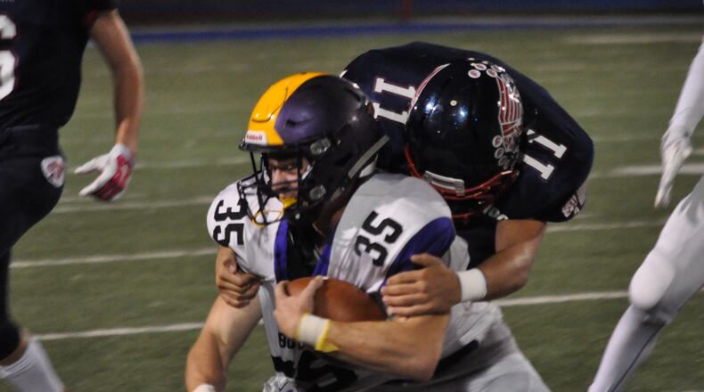 Bulter senior Logan Flatt (35) is tackled by Piqua linebacker Micah Karn during a Week 8 contest at Piqua High School Oct. 12, 2017. NICK DUDUKOVICH / CONTRIBUTED