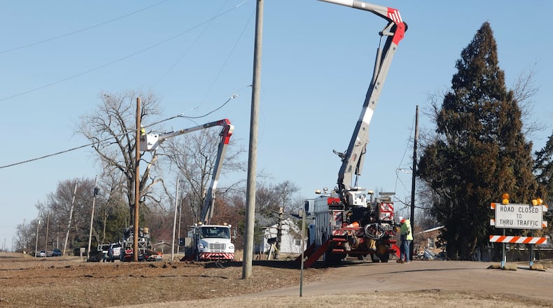 Ohio Edison crews replace utility poles along Fletcher Pike Thursday. BILL LACKEY/STAFF