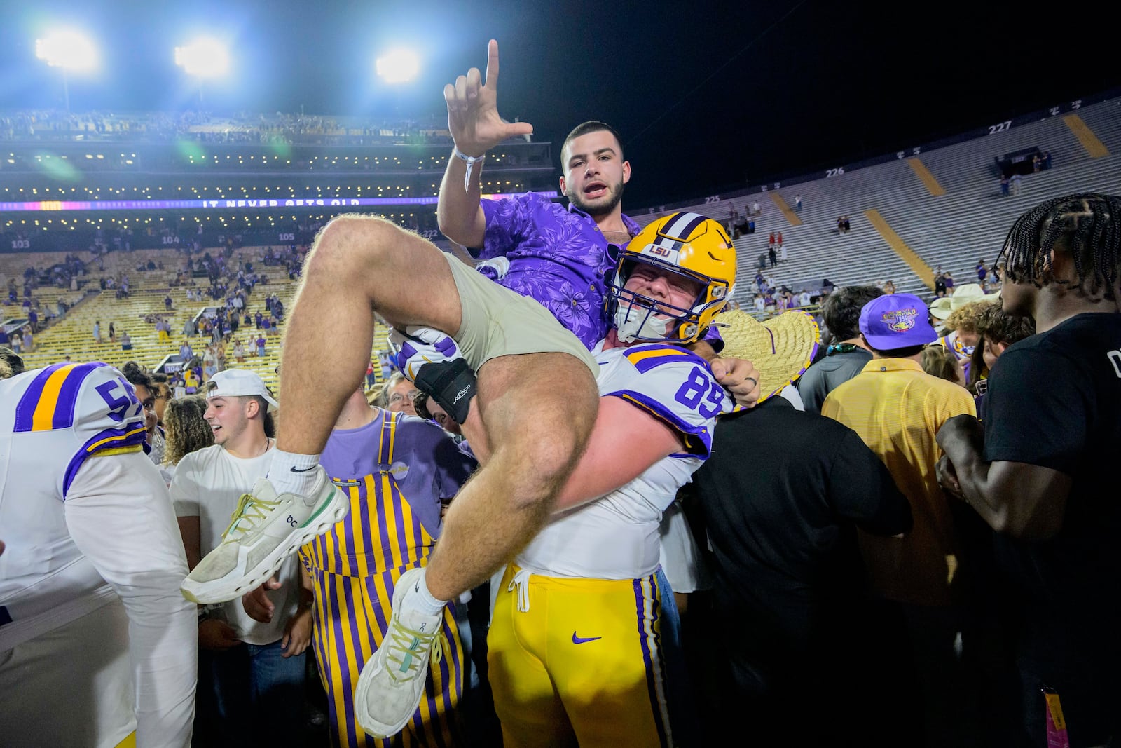 FILE - LSU offensive lineman Bo Bordelon (89) celebrates with LSU fans after they rushed the field after the team's overtime victory over Mississippi in an NCAA college football game in Baton Rouge, La., Saturday, Oct. 12, 2024. (AP Photo/Matthew Hinton, File)