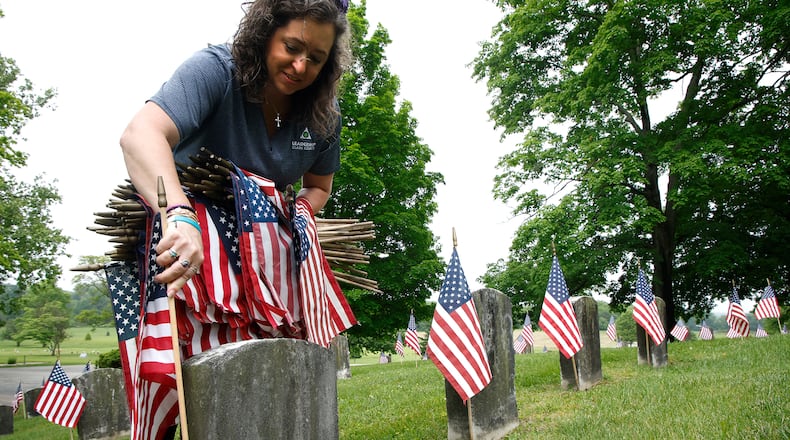 Mindy Allender joined the volunteers Saturday morning, May 18, 2024 as they placed over 3,000 American flags on the graves of service men and women interred in Ferncliff Cemetery for Memorial Day. Over 40 volunteers, including a large group from Werner Enterprises, placed flags on the central GAR (Civil War) mound, WWI section, WWII section and the Annex with more recent graves. The event was organized by Ferncliff Cemetery and Arboretum. BILL LACKEY/STAFF